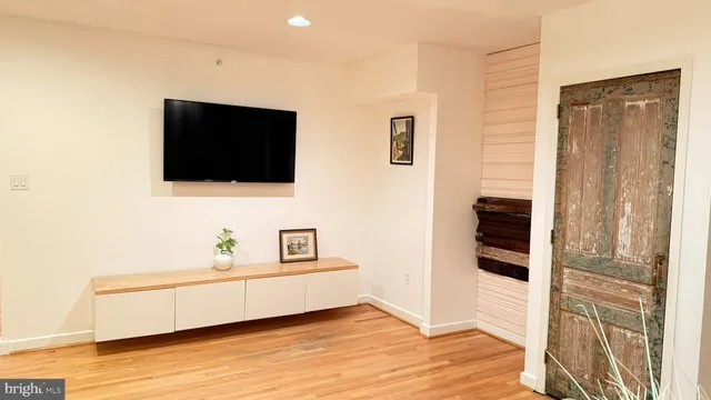 a spacious bathroom with a bathtub and a flat screen tv