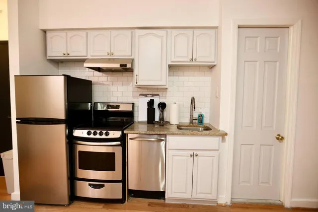 a kitchen with stainless steel appliances granite countertop a stove a refrigerator and a cabinets