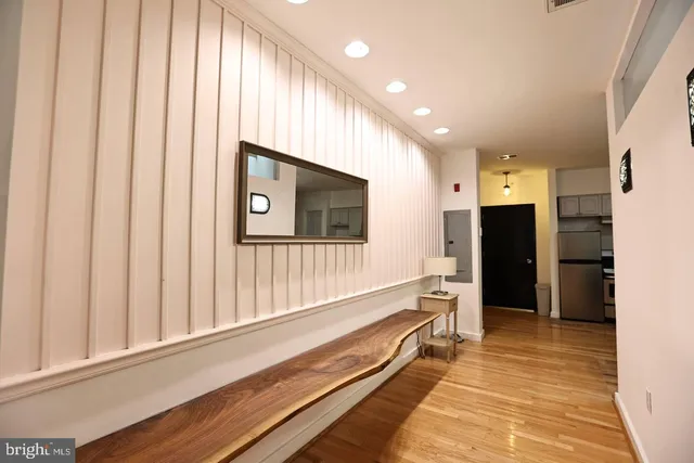 a view of a hallway with wooden floor and staircase