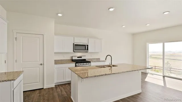 a kitchen with stainless steel appliances granite countertop a sink a stove and a refrigerator