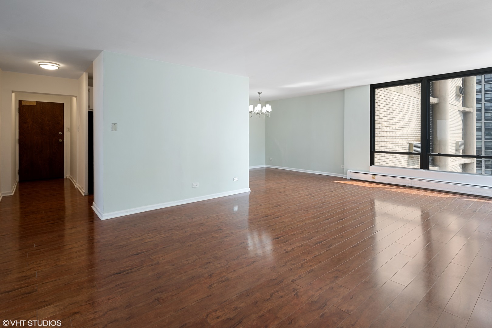5740 North Sheridan Road, Unit 14C Chicago, IL 60660 - Photo 3 of 11 an empty room with wooden floor and windows