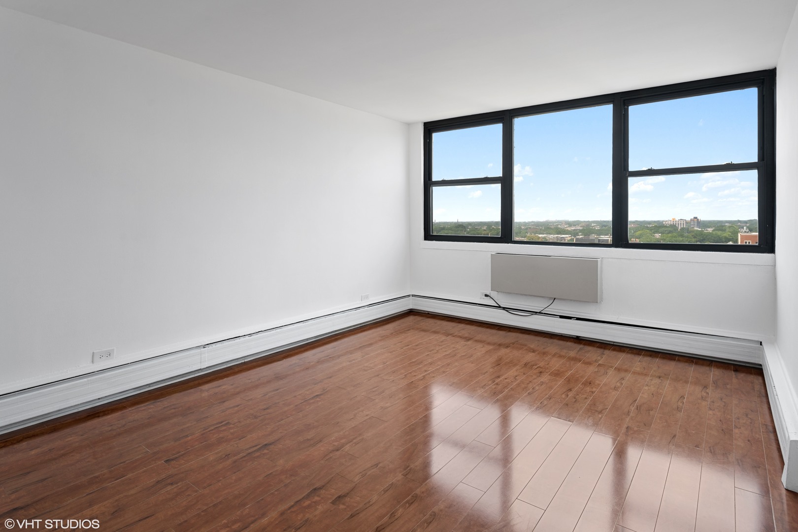 5740 North Sheridan Road, Unit 14C Chicago, IL 60660 - Photo 5 of 11 a view of an empty room with wooden floor and a window