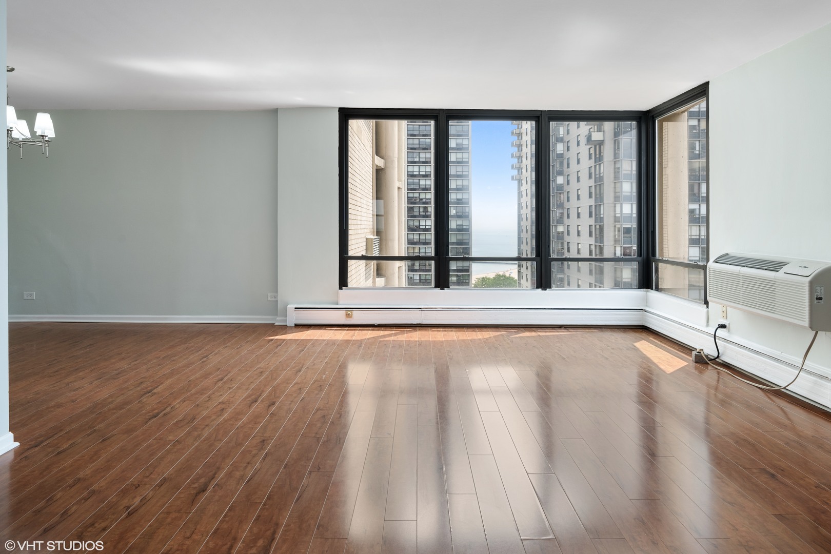 5740 North Sheridan Road, Unit 14C Chicago, IL 60660 - Photo 7 of 11 a view of an empty room with wooden floor and a window