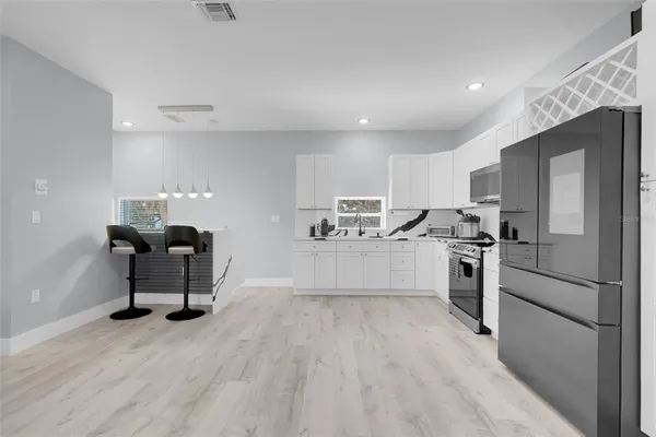 a kitchen with stainless steel appliances a stove a sink and a microwave