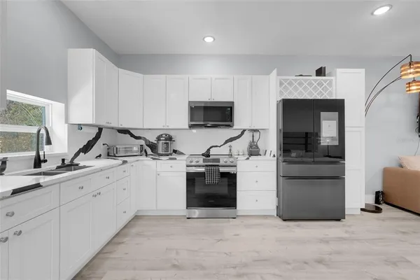 a large bedroom with a bed and a view of kitchen