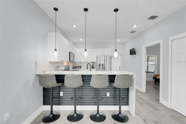 a kitchen with white cabinets and stainless steel appliances