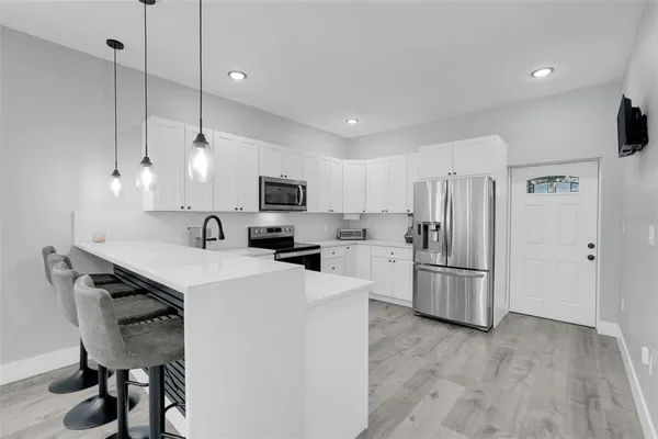 a kitchen with stainless steel appliances granite countertop a stove a sink and a refrigerator