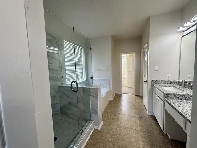 a bathroom with a granite countertop sink a toilet a mirror and shower