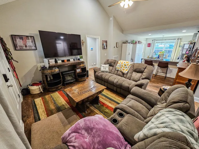 a kitchen with stainless steel appliances granite countertop a sink dishwasher and a refrigerator with wooden floor