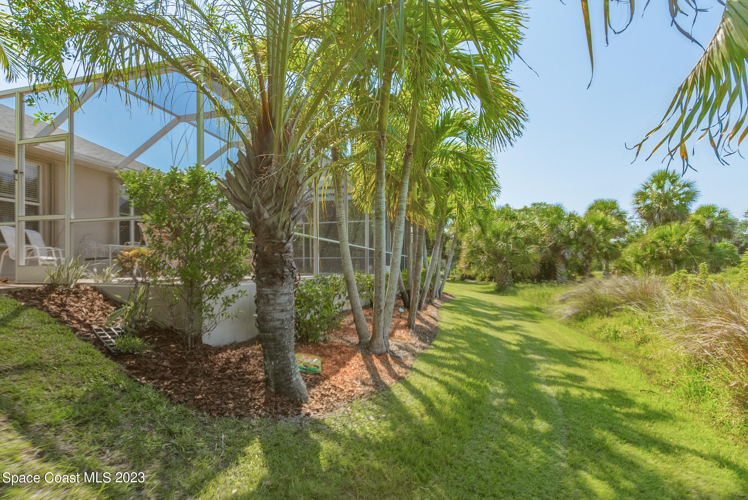4481 Aberdeen Circle Rockledge, FL 32955 - Photo 10 of 70 a backyard of a house with table and chairs under an umbrella