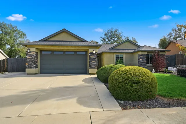 a front view of a house with a garden and garage