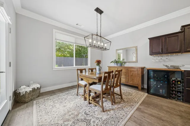 a dining room with furniture a chandelier and wooden floor