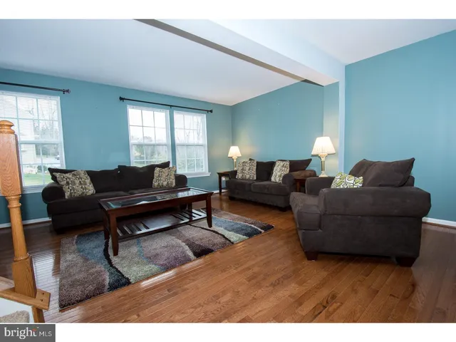 a living room with furniture a rug and a window