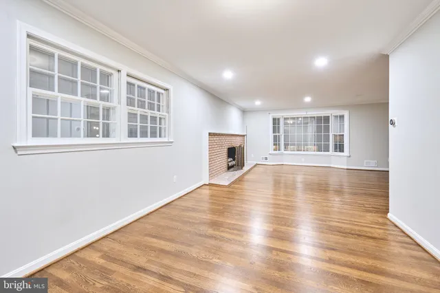a view of empty room with wooden floor and fireplace