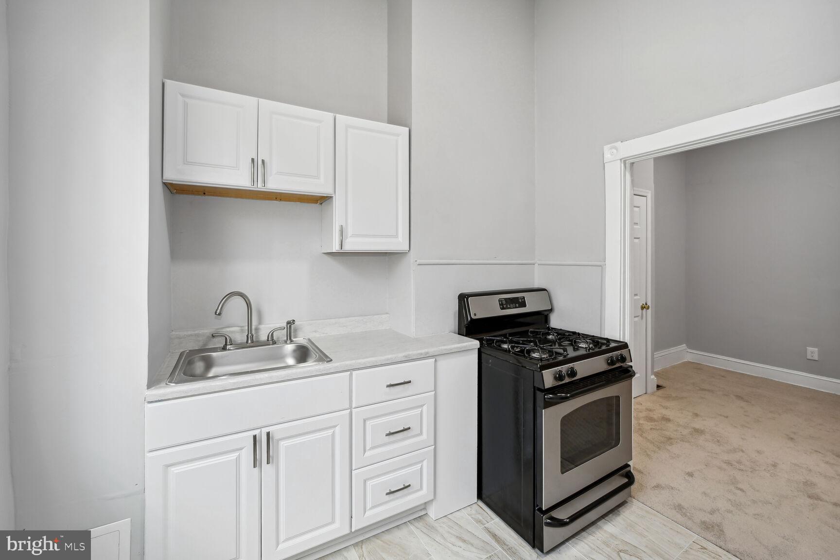 1909 McCulloh Street Baltimore, MD 21217 - Photo 7 of 22 a kitchen with granite countertop white cabinets and stainless steel appliances