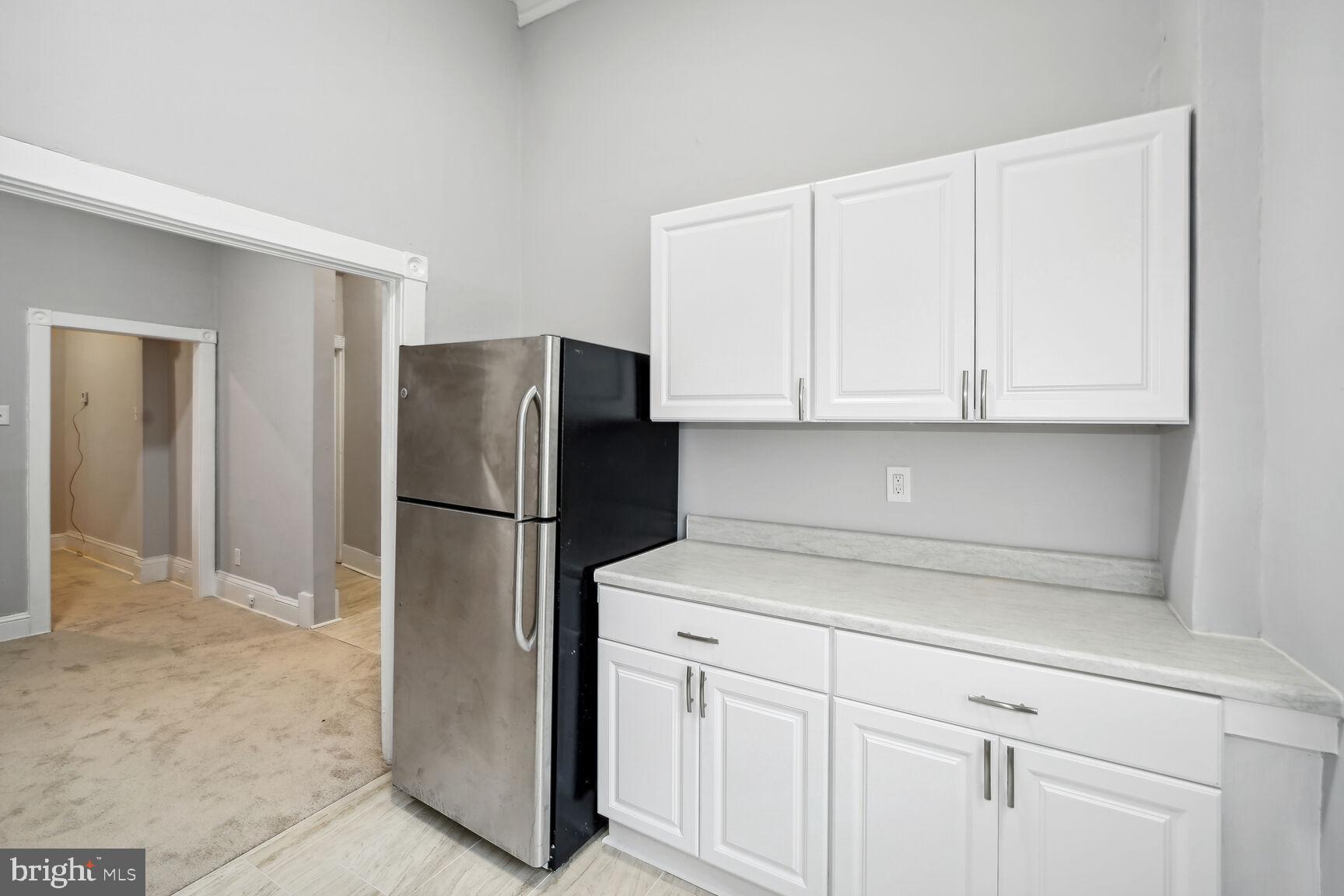 1909 McCulloh Street Baltimore, MD 21217 - Photo 8 of 22 a kitchen with white cabinets and refrigerator