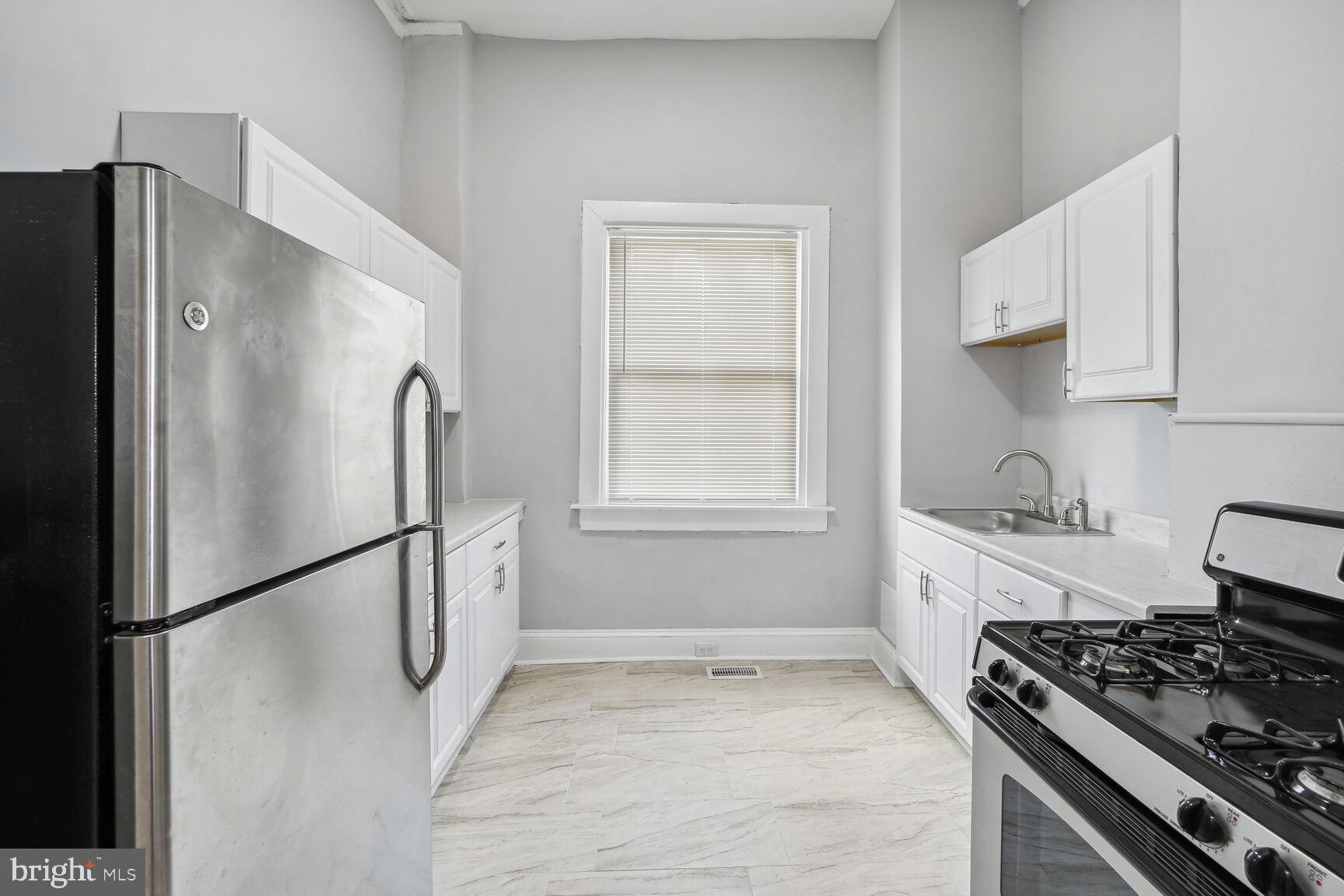 1909 McCulloh Street Baltimore, MD 21217 - Photo 9 of 22 a kitchen with stainless steel appliances a refrigerator a stove a sink and a window