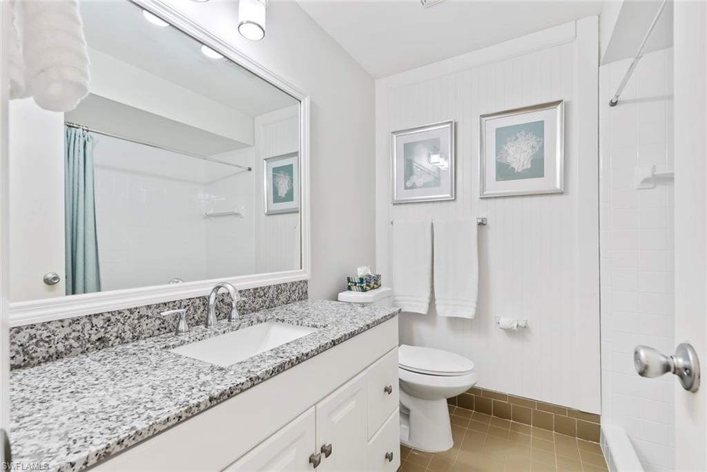 136 Harrison Road, Unit 1 Naples, FL 34112 - Photo 12 of 29 Bathroom with a granite-style countertop, integrated sink, and white vanity cabinetry