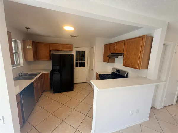 a kitchen with stainless steel appliances a refrigerator sink and cabinets