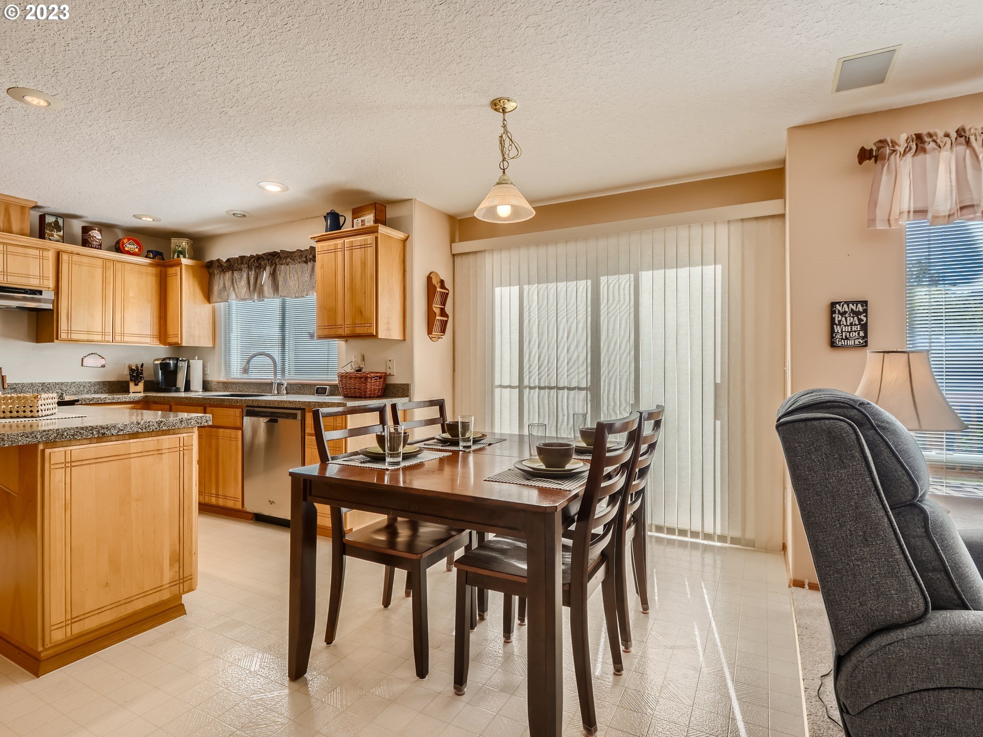 1167 Southeast Eagle Lane Gresham, OR 97080 - Photo 7 of 25 a kitchen with stainless steel appliances granite countertop a table chairs sink and cabinets