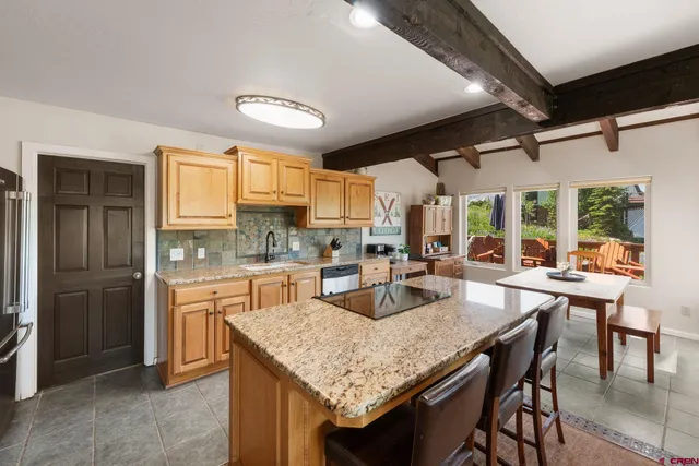 a kitchen with granite countertop kitchen island a table and chairs in it