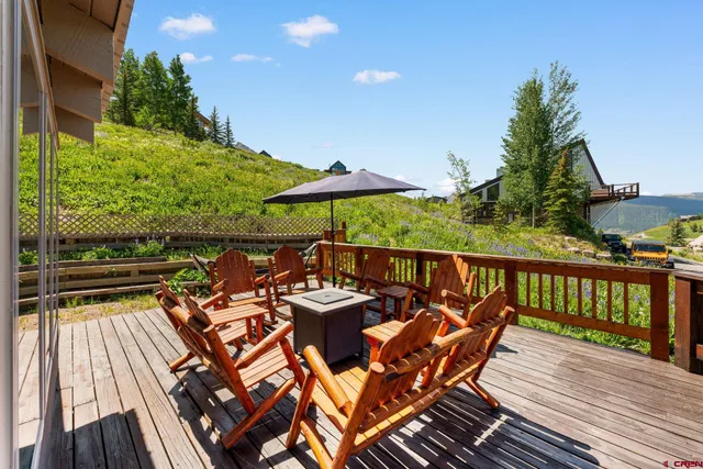 a balcony with wooden floor table and chairs