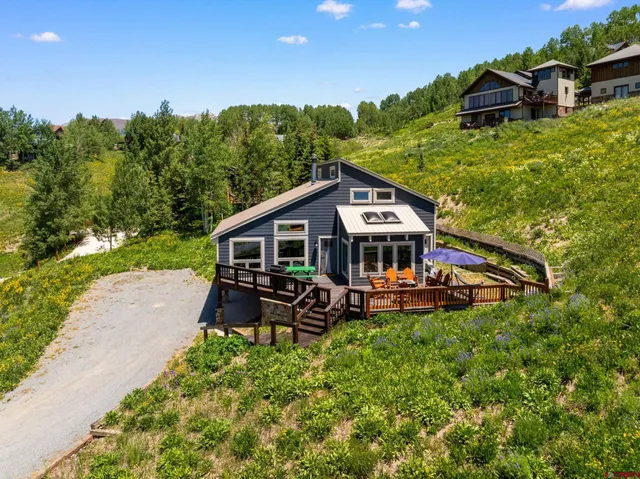 a aerial view of a house with table and chairs under an umbrella