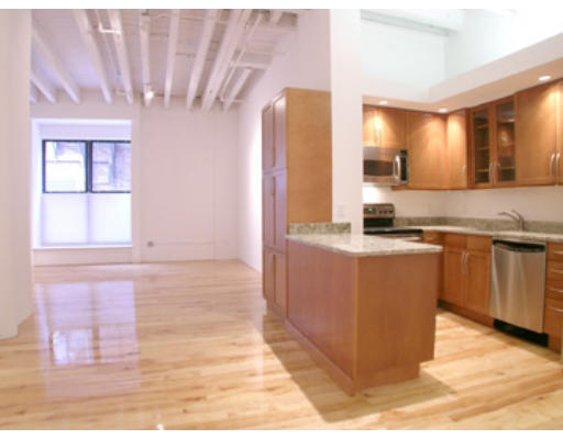 111 Beach Street, Unit 1E Boston, MA 02111 - Photo 1 of 1 a kitchen with kitchen island granite countertop a sink counter top space and cabinets