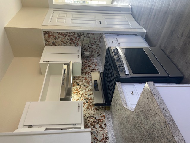 1034 Magnolia Street Lockhart, TX 78644 - Photo 8 of 12 Kitchen featuring stainless steel range oven, ventilation hood, white cabinets, and light countertops