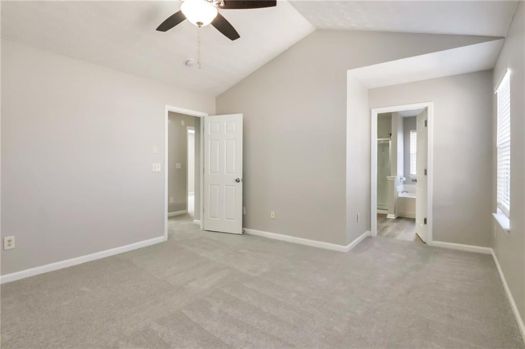 344 Springbottom Court Southeast Lawrenceville, GA 30046 - Photo 21 of 26 an empty room with chandelier fan and windows
