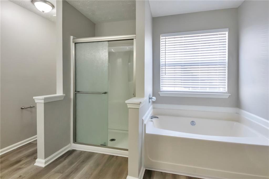 344 Springbottom Court Southeast Lawrenceville, GA 30046 - Photo 23 of 26 a bathroom with a bathtub and a shower