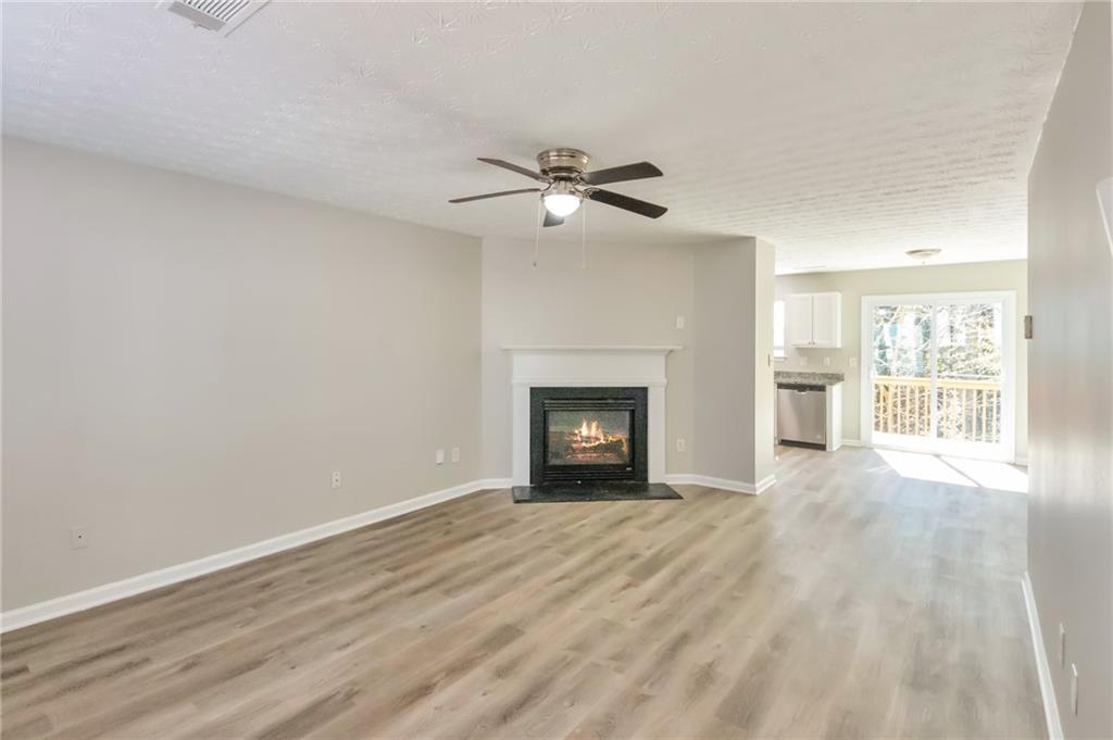 344 Springbottom Court Southeast Lawrenceville, GA 30046 - Photo 4 of 26 wooden floor fireplace and windows in an empty room