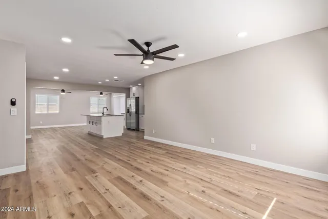 a view of empty room with wooden floor and a ceiling fan