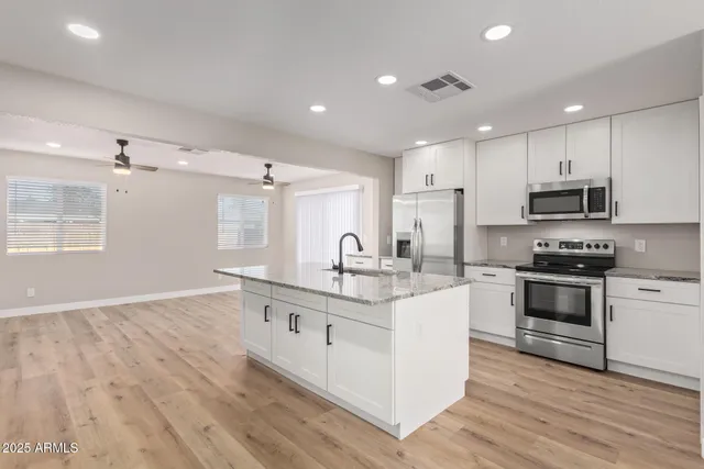 a kitchen with a sink and dishwasher with wooden floor