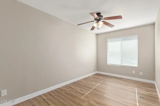 an empty room with closet and a chandelier fan