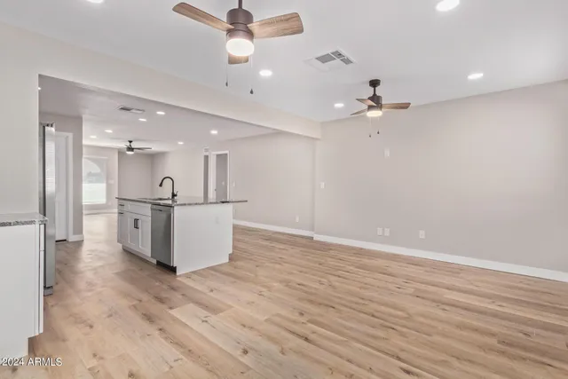 wooden floor in an empty room with a kitchen