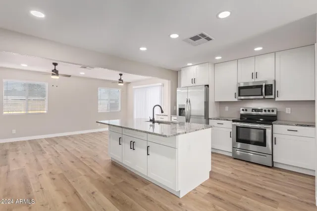 a kitchen with stainless steel appliances granite countertop a sink stove and refrigerator
