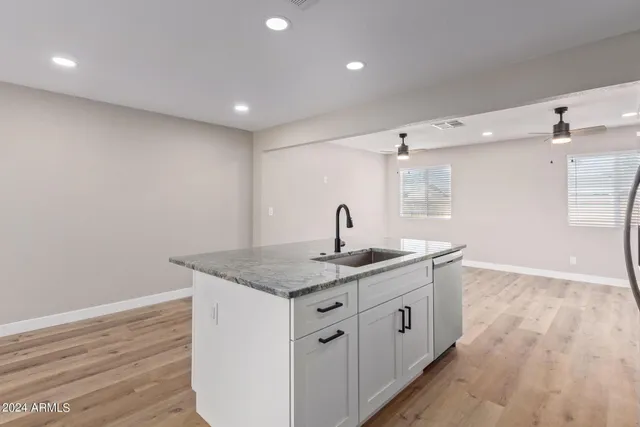 a kitchen with sink and mirror