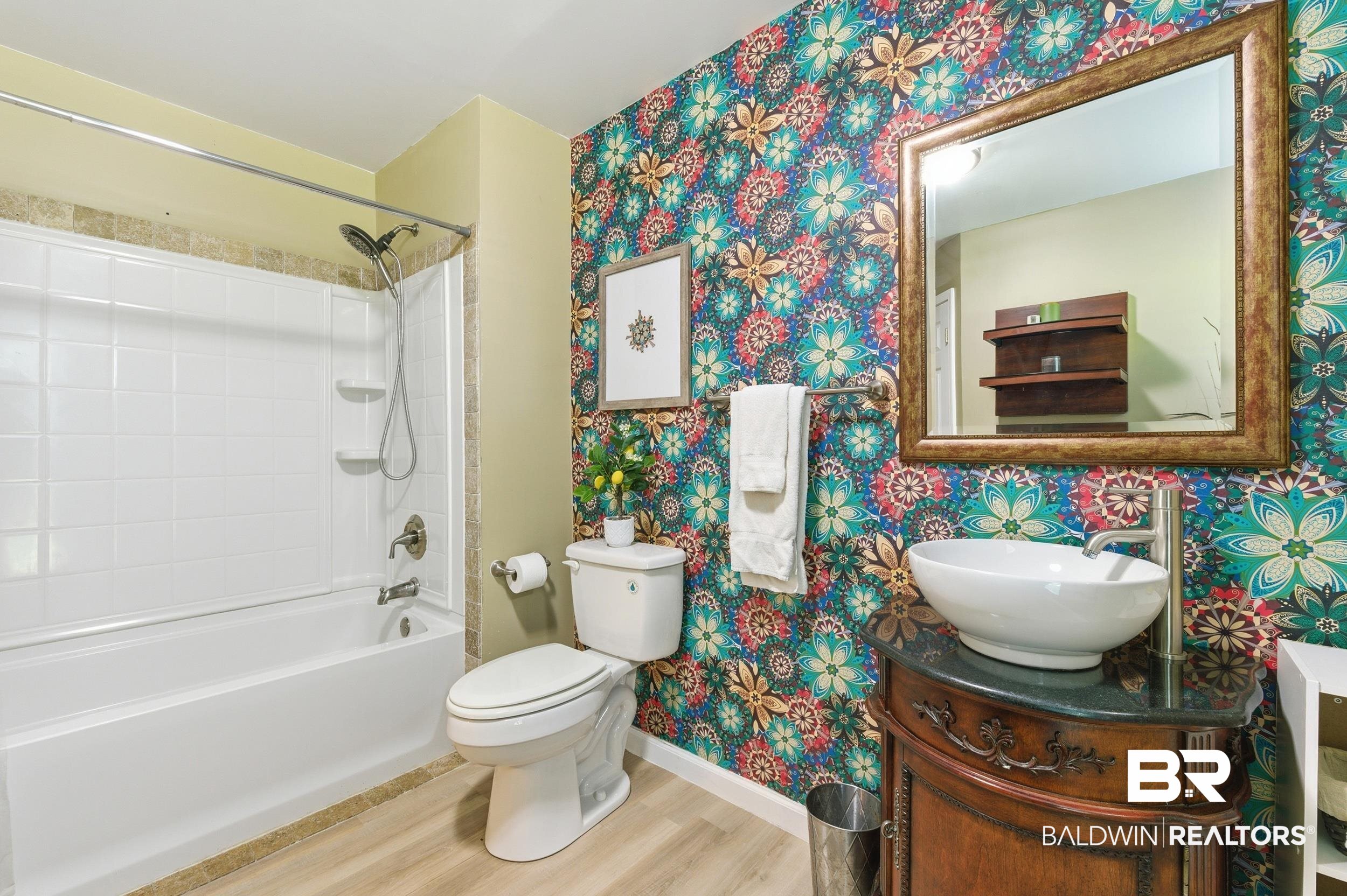 51620 Robert White Road Bay Minette, AL 36507 - Photo 15 of 81 Bathroom featuring a tub/shower combination with white subway tile surround, a vessel sink on a dark vanity with a stone countertop, a gold-framed mirror, and wood-finish flooring