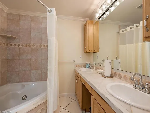 a bathroom with a tub sink and mirror