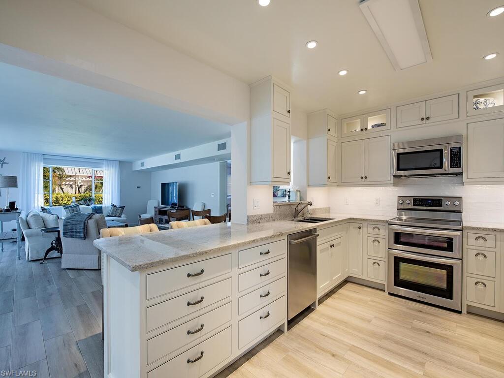 271 1st Avenue South Naples, FL 34102 - Photo 4 of 14 a kitchen with a stove a sink and a refrigerator