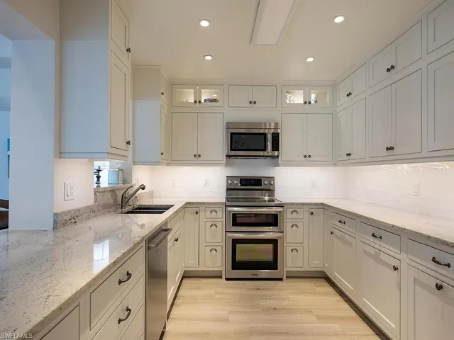 a kitchen with cabinets stainless steel appliances and a sink