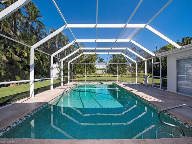 a view of a backyard with table and chairs under an umbrella