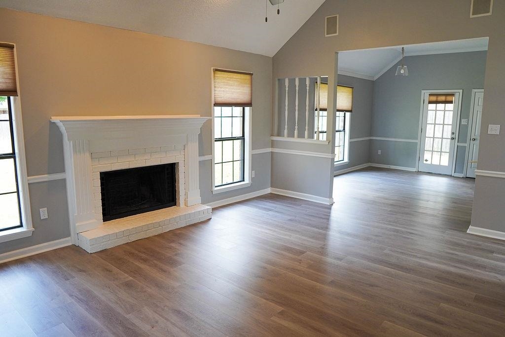 5488 Ross Road Memphis, TN 38141 - Photo 4 of 18 an empty room with wooden floor fireplace and windows