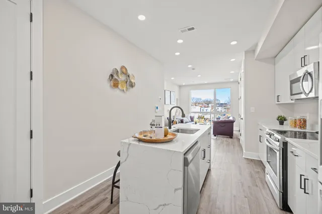 a kitchen with a refrigerator a stove and a dining table with wooden floor