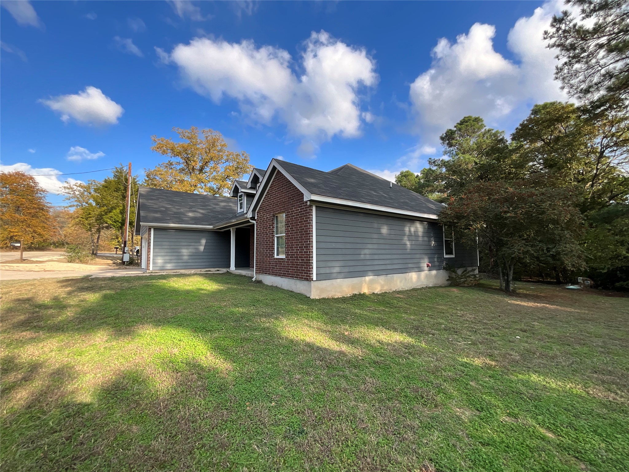 239 Old Firetower Road Bastrop, TX 78602 - Photo 15 of 39 View of home's exterior with a yard and brick siding