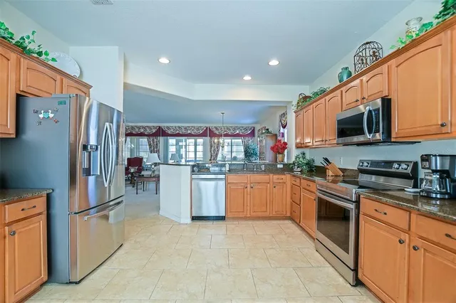 a kitchen with stainless steel appliances granite countertop a refrigerator a stove top oven a sink and dishwasher