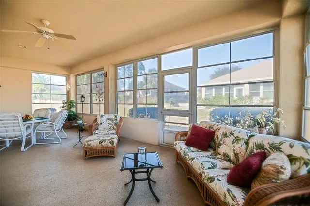 a living room with furniture and a floor to ceiling window