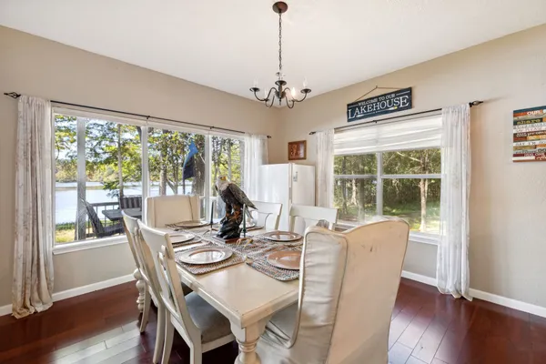 a view of a dining room with furniture a chandelier and wooden floor
