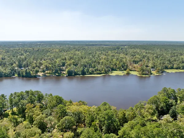an aerial view of a houses with yard and mountain view in back